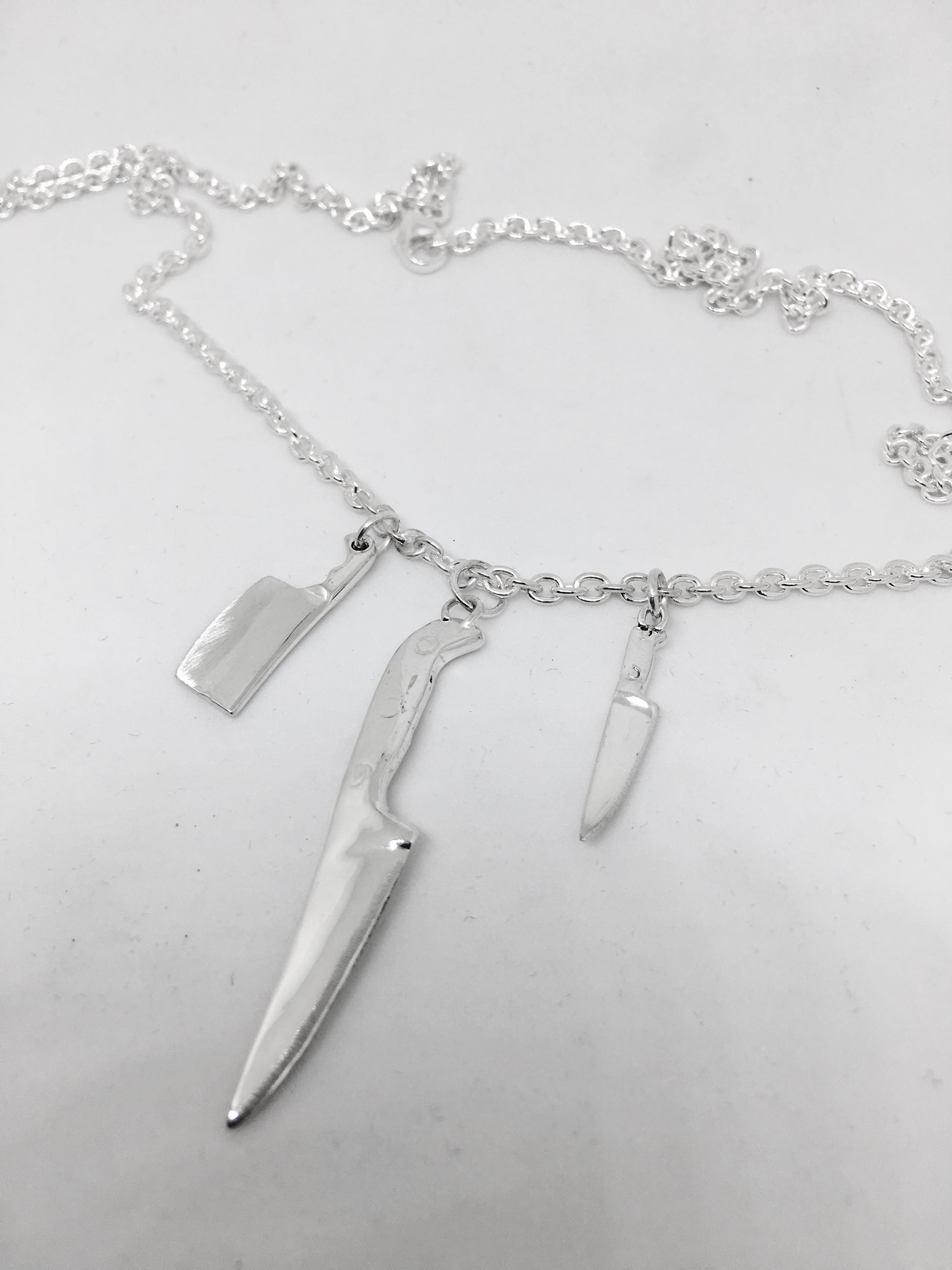 the triple knife necklace has a lobster clasp